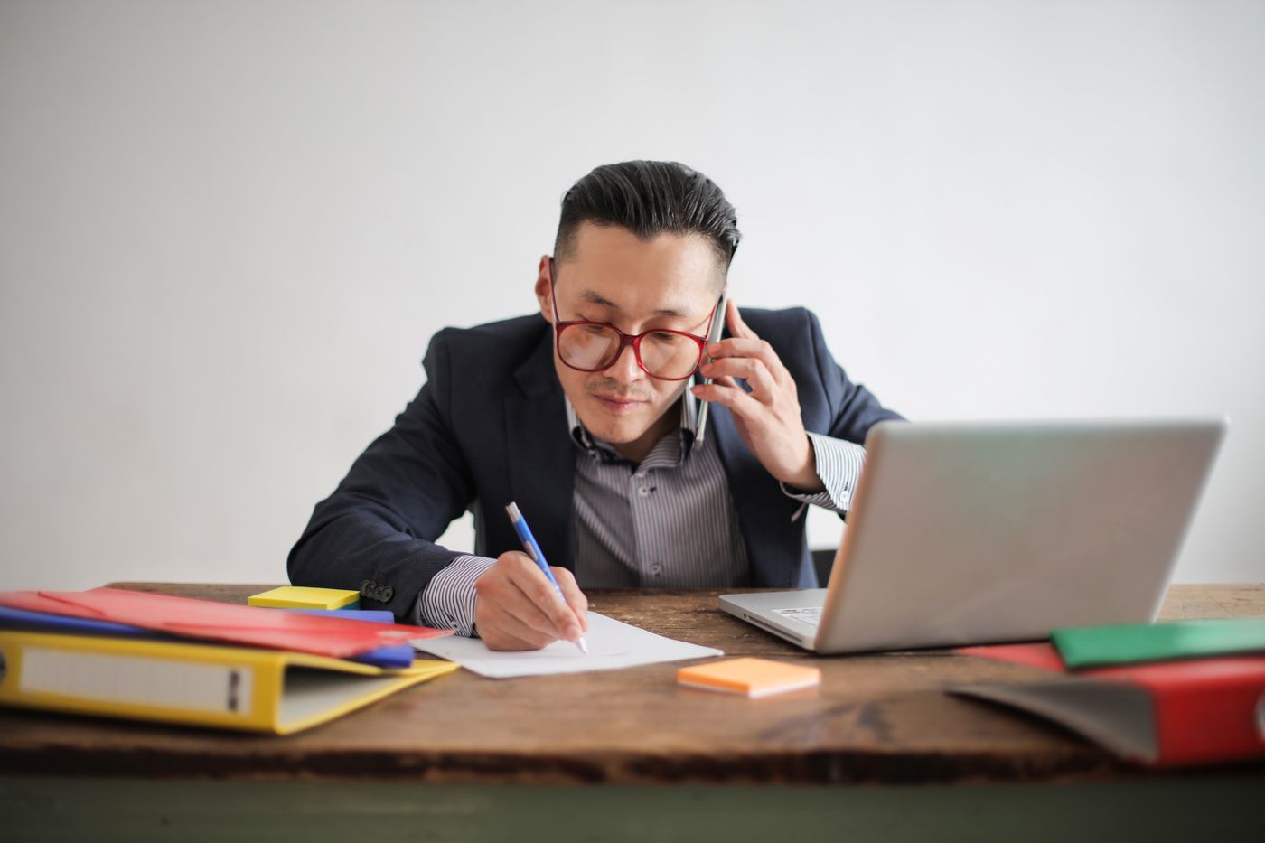 A sales administrator on a phone call at a desk with a laptop