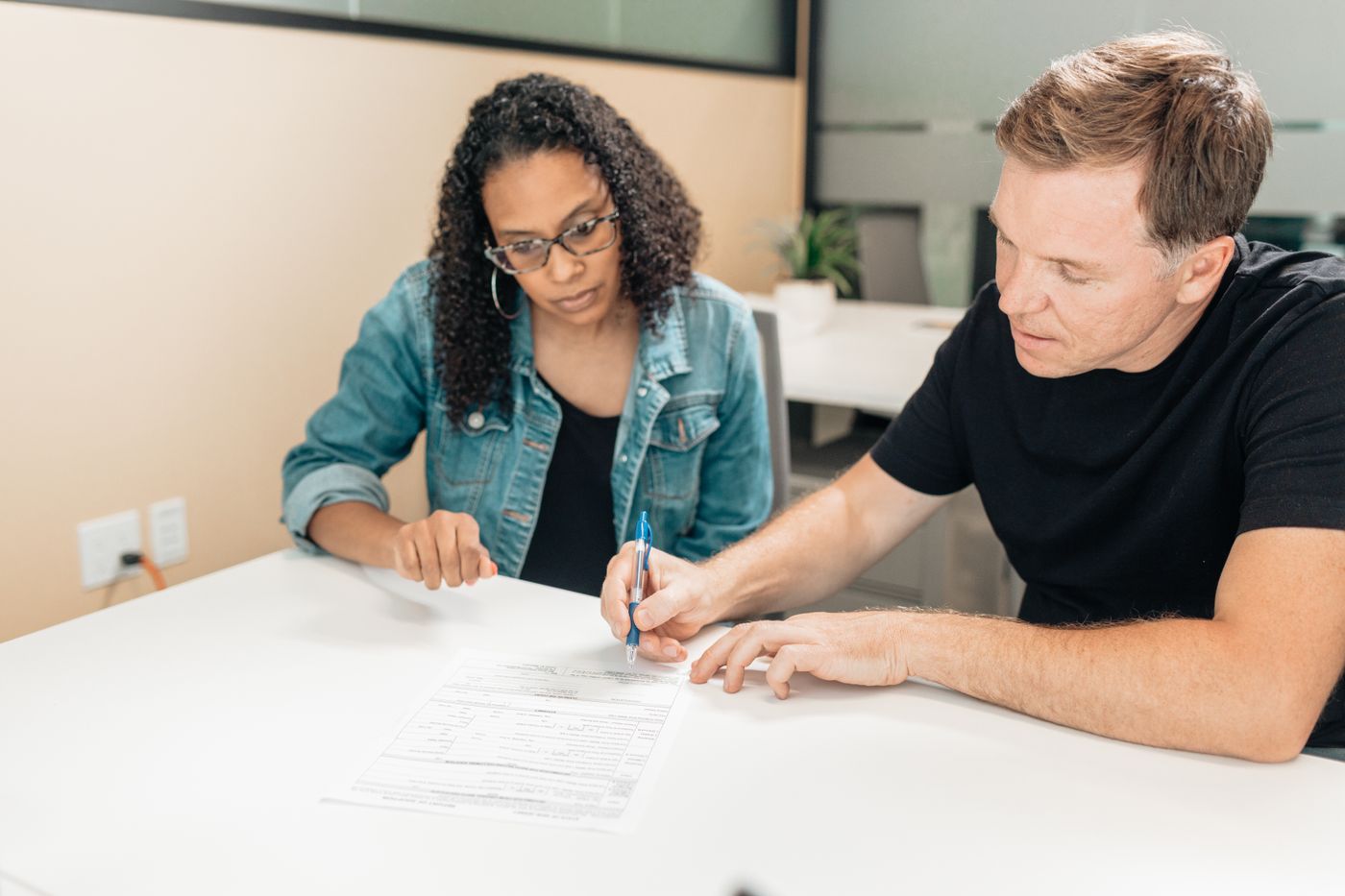 Two buyers signing papers at a desk