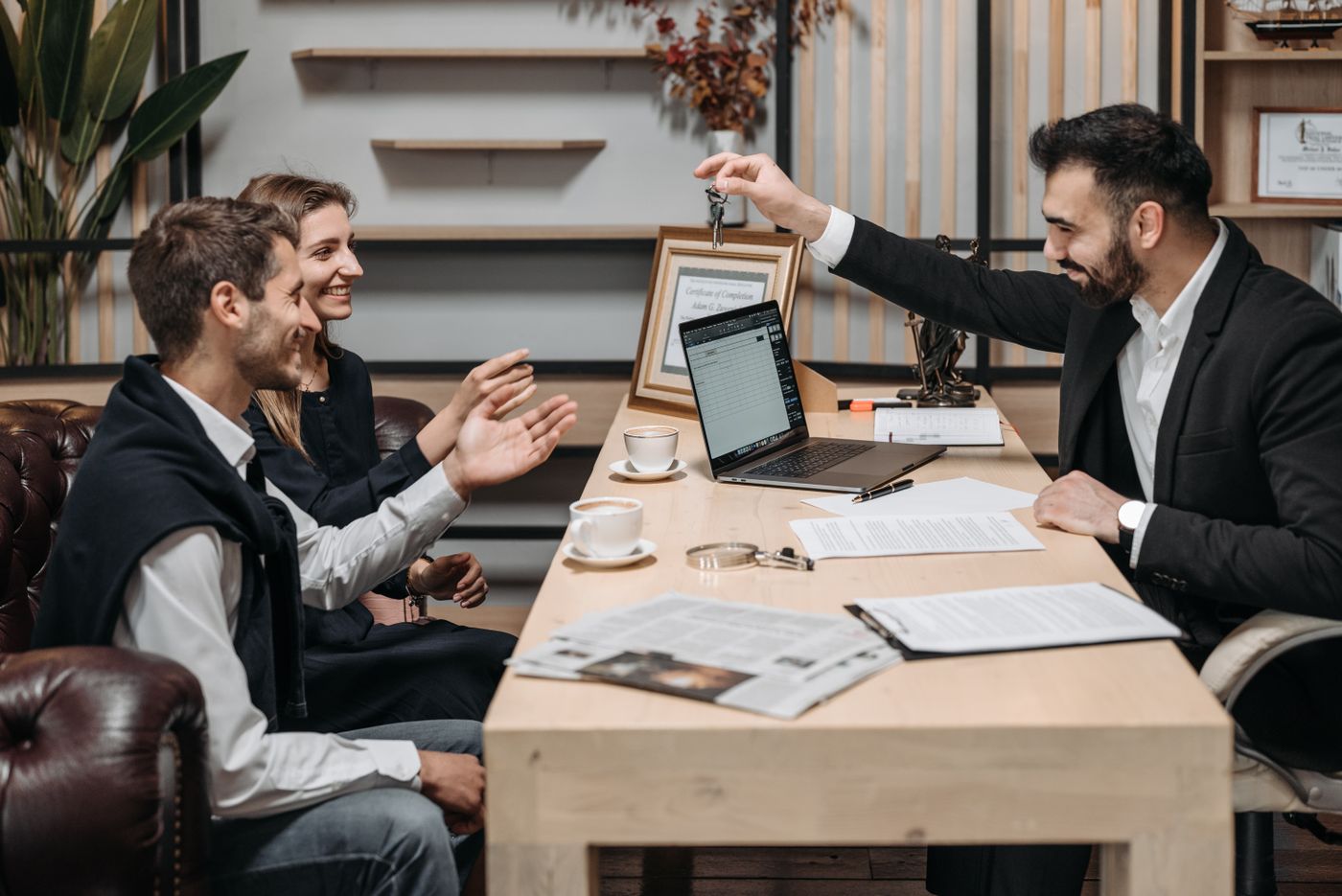 A sales consultant going through details with buyers at a desk