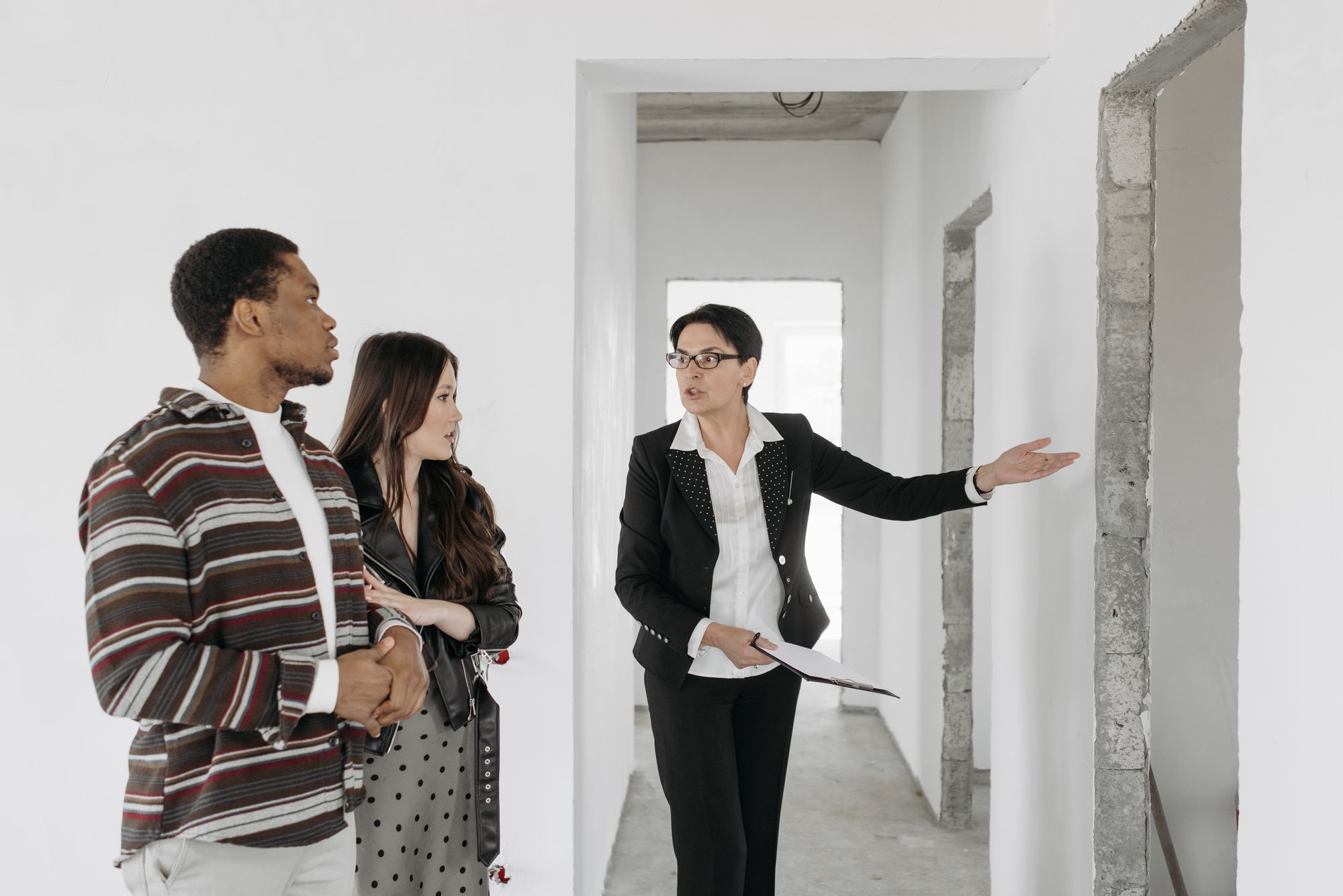A sales consultant showing two buyers around a new unit