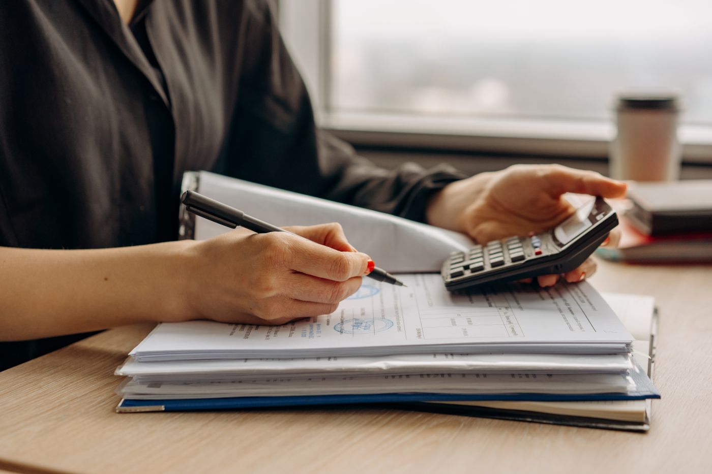 A finance officer checking documents with a calculator